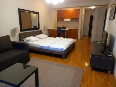 a room with a bed and a couch and a television at Moka in Belgrade