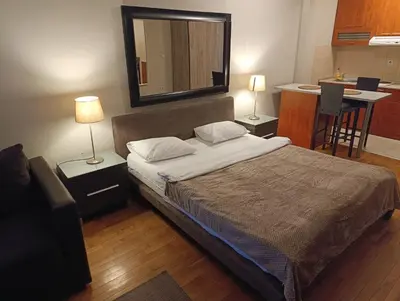 a bedroom with a bed with a mirror and a kitchen at Moka in Belgrade