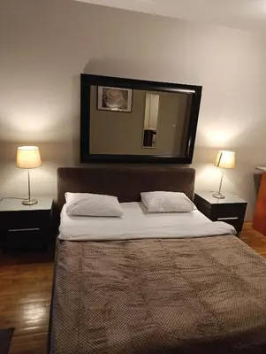 a bedroom with a bed with a mirror on the wall at Moka in Belgrade