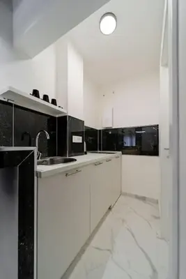 a white kitchen with a sink and white cabinets at Dark Nest 3 Belgrade Apartments in Zvezdara