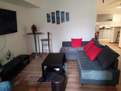 a living room with a blue couch and red pillows at Apartman Dimitrijala 52 in Zvezdara