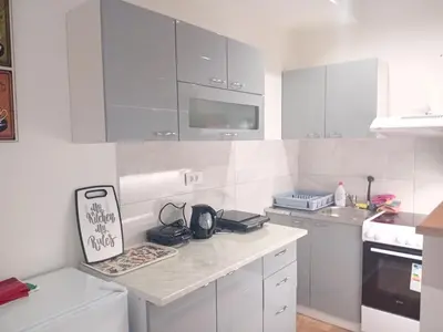 a kitchen with white cabinets and a counter top at Apartman Dimitrijala 52 in Zvezdara