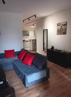 a living room with a blue couch and red pillows at Apartman Dimitrijala 52 in Zvezdara