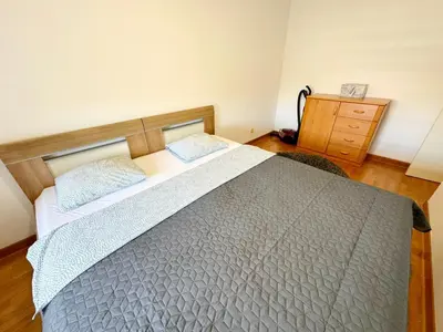 a bedroom with a large bed and a wooden dresser at Apartment B5 in Belgrade