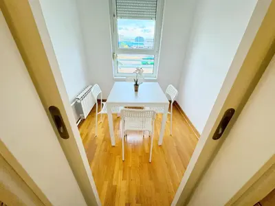 a table and chairs in a room with a window at Apartment B5 in Belgrade