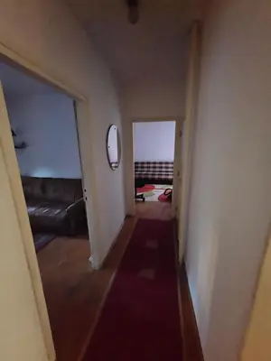 a hallway leading to a room with a couch and a bed at Stan na karaburmi in Rospi Ćuprija