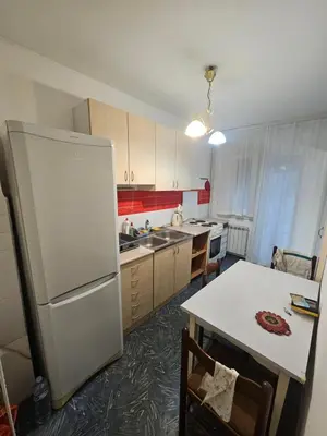 a kitchen with a white refrigerator and a table at Stan na karaburmi in Rospi Ćuprija