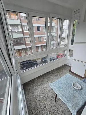 a room with three windows and a table in front of it at Stan na karaburmi in Rospi Ćuprija