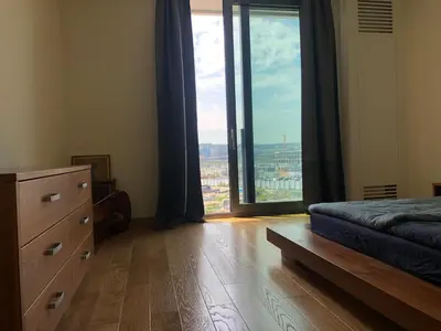 a bedroom with a bed and a dresser and a large window at Exquisite BW Residences 210sqm condo in Sajmište