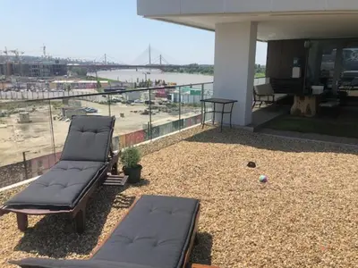 two chaise lounges on a patio with a view of a river at Exquisite BW Residences 210sqm condo in Sajmište