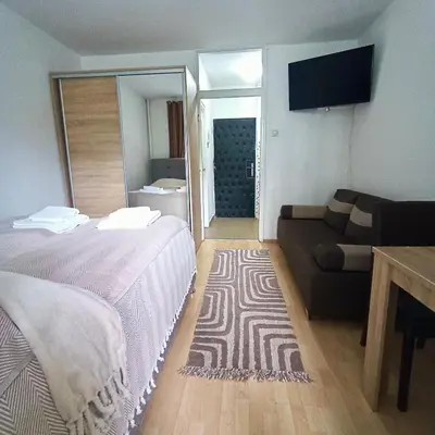 a hotel room with two beds and a couch at Fontana cozy apartment near Danube river in Belgrade