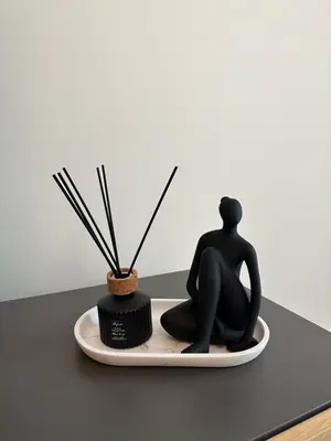 a statue of a person sitting on a plate with a plant at ALPHA LUX - Galerija mall view - Beograd na vodi in Belgrade