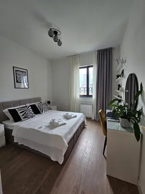 a white bedroom with a large bed and a desk at ALPHA LUX - Galerija mall view - Beograd na vodi in Belgrade