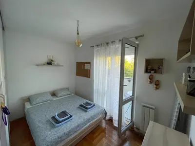 a bedroom with a bed and a sliding glass door at Comfy & Cozy Apartment - parking in Karaburma
