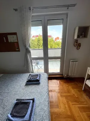 a room with a bed and a large window at Comfy & Cozy Apartment - parking in Karaburma