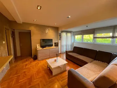 a living room with a couch and a tv at Comfy & Cozy Apartment - parking in Karaburma