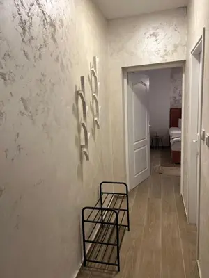 a hallway with a chair and a wall with marble at Anna apartment in Belgrade