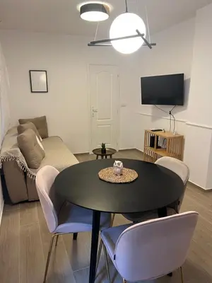 a living room with a table and chairs and a couch at Anna apartment in Belgrade