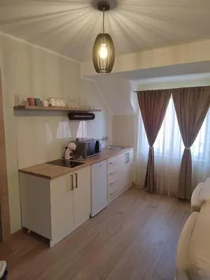 a kitchen with white cabinets and a counter top at Apartman Anđela in Jakovo
