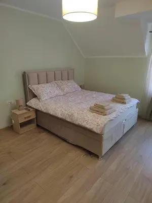 a bedroom with a large bed with a wooden floor at Apartman Anđela in Jakovo
