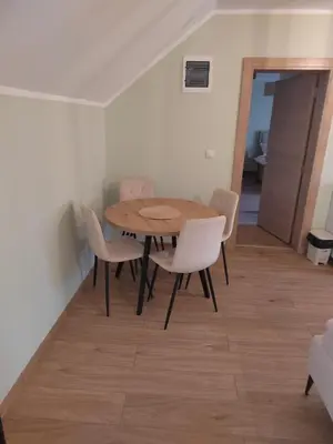 a dining room with a wooden table and chairs at Apartman Anđela in Jakovo