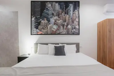 a bedroom with a white bed with a picture on the wall at Fera in Belgrade