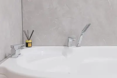 a bathroom sink with two faucets and a mirror at Fera in Belgrade