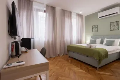 a bedroom with a bed and a desk and a television at Fera in Belgrade