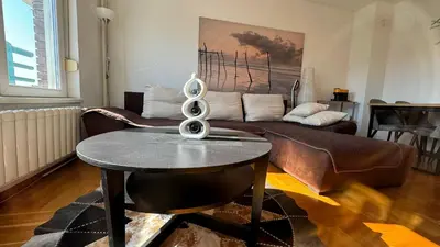 a living room with a couch and a table at Arena BGD - Hadrianz Apartment in Novi Beograd