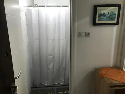 a shower with a white shower curtain in a bathroom at Near Highway free parking apartment in Rakovica