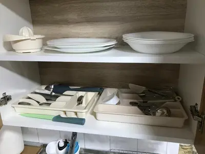 two white plates and bowls on a shelf at Near Highway free parking apartment in Rakovica