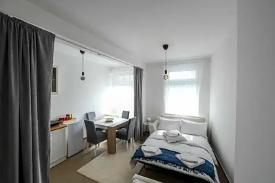 a bedroom with a bed and a desk and a table at Paun Apartmani in Smederevo
