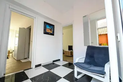 a room with a blue chair and a black and white floor at Paun Apartmani in Smederevo