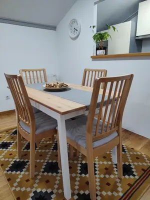 a dining room table with three chairs and a plate on it at Apartman Ingrid in Belgrade