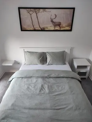 a bedroom with a bed with a picture of a deer on the wall at Apartman Ingrid in Belgrade