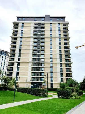 a tall apartment building with a lawn in front of it at Delux Simfonija Belgrade Waterfront in Sajmište