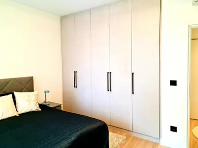 a bedroom with white cabinets and a bed at Delux Simfonija Belgrade Waterfront in Sajmište