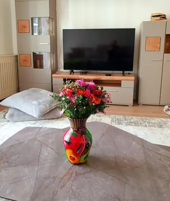 a colorful vase with flowers in a living room at Delux Simfonija Belgrade Waterfront in Sajmište