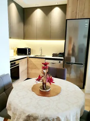 a kitchen with a table with a flower arrangement on it at Delux Simfonija Belgrade Waterfront in Sajmište