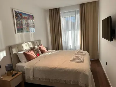a bedroom with a bed with pillows and a window at Apartman Kosmajska Vila in Rogača