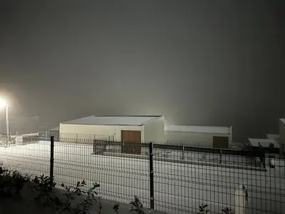 a tennis court with a fence and a building at Apartman Kosmajska Vila in Rogača