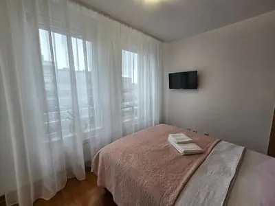 a bedroom with a bed and a large window at Akacija - Belvil in Belgrade