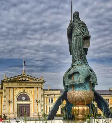 a statue of a man standing in front of a building at Akacija - Belvil in Belgrade
