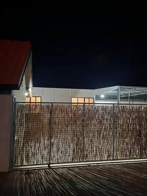 a fence in front of a building at night at Lokal za zurke, slavlja i rodjendane in Pećinci
