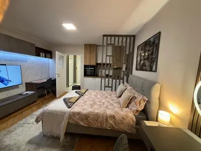 a bedroom with a bed and a living room at Mina 2 in Belgrade