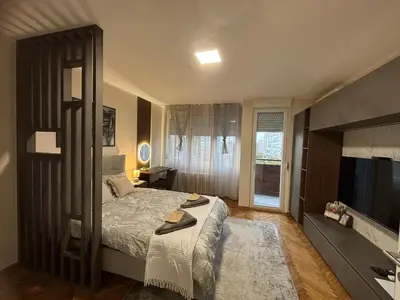 a bedroom with a large bed and a television at Mina 2 in Belgrade