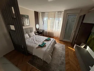 a bedroom with a bed and a large window at Mina 2 in Belgrade