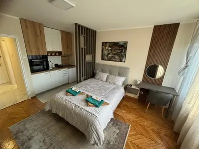 a small bedroom with a bed and a kitchen at Mina 2 in Belgrade