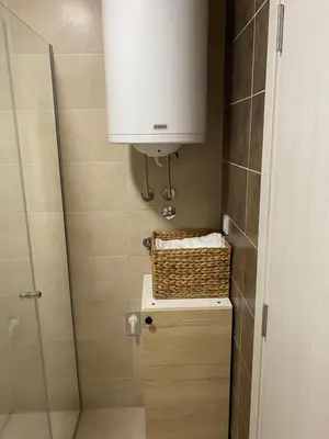 a bathroom with a shower and a sink and a basket at Green Residence in Belgrade