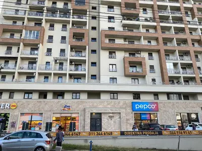 a large apartment building with cars parked in front of it at Green Residence in Belgrade